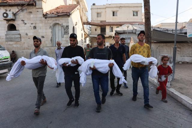 Palestinian men carry the bodies of children killed earlier in the day in an Israeli strike in Gaza City, during a funeral precession from Baptist Hospital to a cemetary, on July 2, 2025, amid the ongoing conflict between Israel and the Palestinian Hamas militant group. (Photo by Omar AL-QATTAA / AFP)