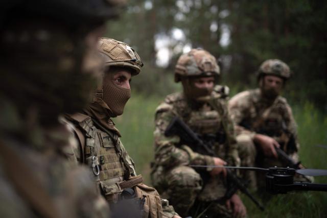 (FILES) Soldiers from the "Black Sky" battalion of the Spartan brigade rest after a demonstration to AFP, at an undisclosed location not far from the front line, in the region of Dnipropetrovsk, Ukraine, on June 14, 2025, amid the russian invasion of Ukraine. Ukraine appealed to the United States for clarity on July 1, 2025, after it was caught off guard by a White House announcement that Washington was halting some arms shipments to the war-battered country. The White House had said that it was halting some key weapons shipments promised by the previous US administration, without elaborating. (Photo by Florent VERGNES / AFP)