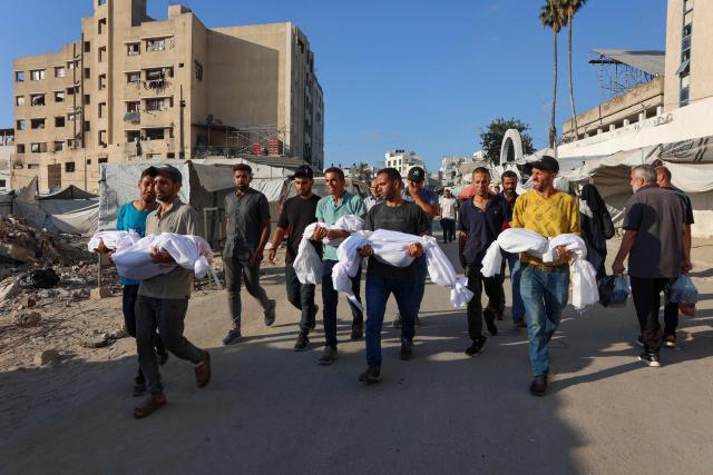 Palestinian men carry the bodies of children killed earlier in the day in an Israeli strike in Gaza City, during a funeral precession from Baptist Hospital to a cemetary, on July 2, 2025, amid the ongoing conflict between Israel and the Palestinian Hamas militant group. (Photo by Omar AL-QATTAA / AFP)