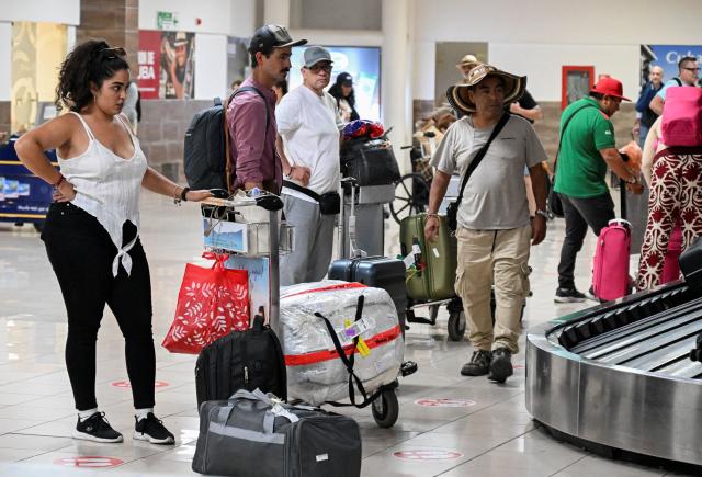 Passengers wait for their luggage upon arrival at Jose Marti International Airport in Havana on July 2, 2025. Stricter protocols will characterize the actions promoted by the National Drug Observatory (OND), presented by Cuba on Wednesday at Havana International Airport, with the aim of strengthening the fight against this scourge. (Photo by YAMIL LAGE / AFP)