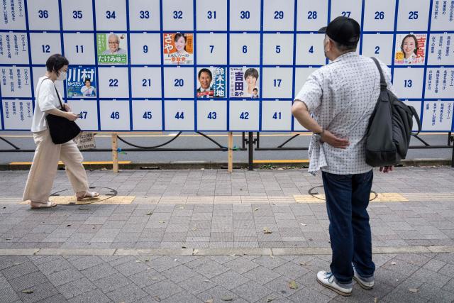 A man looks at an election poster bulletin board ahead of the July 20 upper house election in Tokyo on July 3, 2025. (Photo by Yuichi YAMAZAKI / AFP)