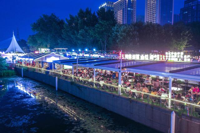 People dine in at a night market in Shenyang, in northeastern China's Liaoning province on July 2, 2025. (Photo by AFP) / China OUT
