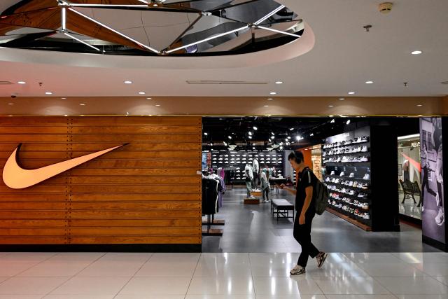 A man walks past a Nike store at a shopping mall in Hanoi July 3, 2025. Stocks struggled in Asia on July 3, 2025 as investors gave a lukewarm reception to the US-Vietnam trade deal, which sent shares of electronics and textile companies soaring — particularly those that supply Nike and Apple and operate in the Southeast Asian country. (Photo by Nhac NGUYEN / AFP)