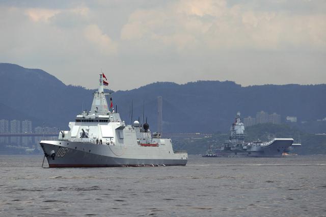 China’s first domestically built aircraft carrier Shandong's (R) escort ship destroyer Yanan is anchored after arriving in Hong Kong on July 3, 2025. Commissioned in 2019, the 305-metre-long (1,000 feet) Shandong is China's second carrier and key to the country's regional ambitions under President Xi Jinping, who oversaw a massive naval buildup that has rattled Asian neighbours. (Photo by May JAMES / AFP)