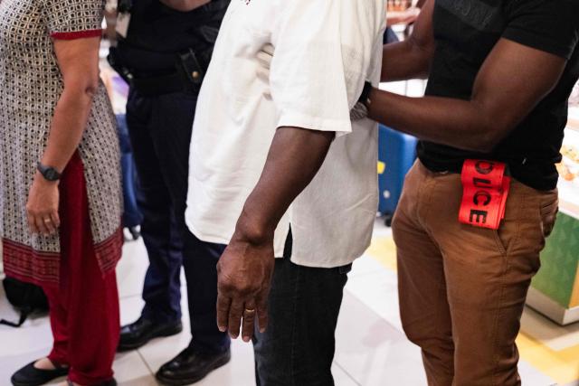 A Police Aux Frontieres, or PAF, (French border police) officer searches a passenger at the security checkpoint during a control operation against drug trafficking at the Maryse Conde airport, in Les Abymes, on the French Caribbean island of Guadeloupe on July 2, 2025. (Photo by Carla Bernhardt / AFP)