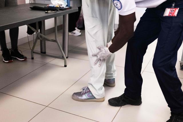 An airport security officer searches a passenger at the security checkpoint during a control operation against drug trafficking at the Maryse Conde airport, in Les Abymes, on the French Caribbean island of Guadeloupe on July 2, 2025. (Photo by Carla Bernhardt / AFP)