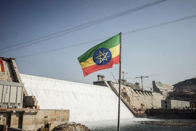 (FILES) This general view shows an Ethiopian national flag flying infront of the Grand Ethiopian Renaissance Dam (GERD) in Guba, Ethiopia, on February 19, 2022. The Grand Ethiopian Renaissance Dam (GERD) is "now complete" announced Ethiopian Prime Minister Abiy Ahmed on July 3, 2025, a project that has been a source of tension with neighboring countries, particularly Egypt. (Photo by Amanuel SILESHI / AFP)