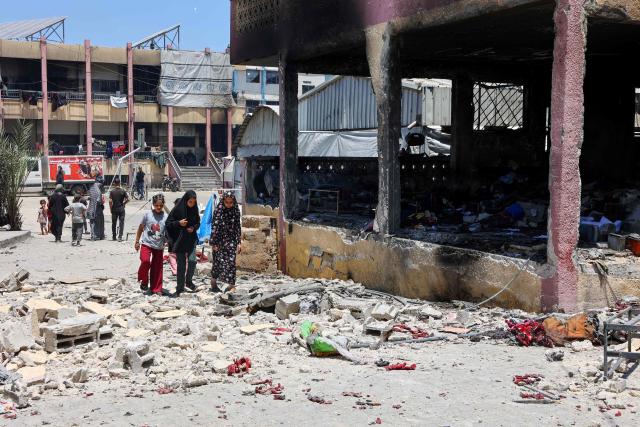People walk over debris at Mustafa Hafez school, sheltering Palestinians displaced by the war, following an overnight Israeli strike in Gaza City, on July 3, 2025, amid the ongoing conflict between Israel and the Palestinian Hamas militant group. (Photo by Omar AL-QATTAA / AFP)