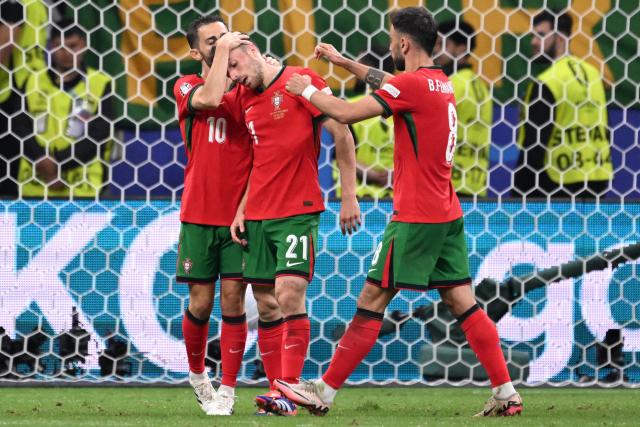 (FILES) Portugal's forward #21 Diogo Jota (C) reacts with Portugal's midfielder #10 Bernardo Silva (L) and Portugal's midfielder #08 Bruno Fernandes during the UEFA Euro 2024 round of 16 football match between Portugal and Slovenia at the Frankfurt Arena in Frankfurt am Main on July 1, 2024. Liverpool striker Diogo Jota died along with his brother early July 3, 2025 in a road accident in northwest Spain, the Spanish Civil Guard said. The accident occurred around 12:30 a.m. on a highway in the province of Zamora. The vehicle "left the road" before bursting into flames, the Civil Guard said, adding that the two passengers, Diogo Jota and his brother Andre Felipe, also a professional footballer, were deceased. (Photo by Kirill KUDRYAVTSEV / AFP)