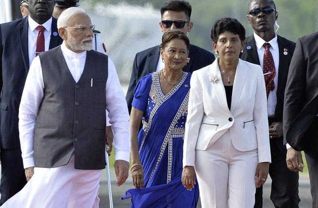 India Prime Minister Prime Minister Narendra Modi (L), Trinidad and Tobago Prime Minister Kamla Persad Bissessar (C) and Andria Narinesingh (R) Chief of Protocol at the Ministry of Foreign and CARICOM walk after arrival at Piarco International Airport in Port of Spain, Trinidad and Tobago on July 3, 2025. Indian Prime Minister Narendra Modi on July 3 began a two-day visit to Trinidad and Tobago, where just over 35% of the population is of Indian descent. (Photo by Robert Taylor / AFP)