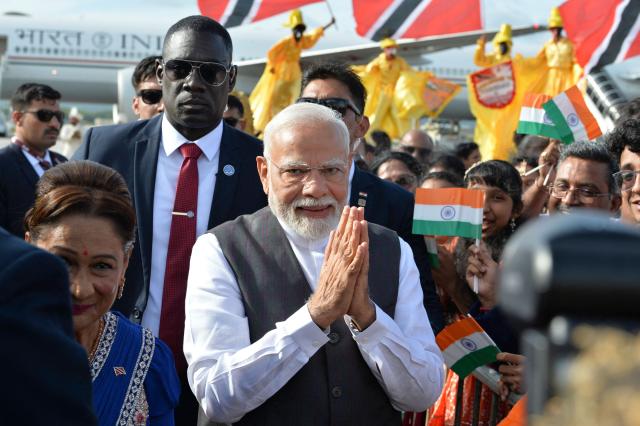 India Prime Minister Prime Minister Narendra Modi greets supporters after arrival at Piarco International Airport in Port of Spain, Trinidad and Tobago on July 3, 2025. Indian Prime Minister Narendra Modi on Thursday began a two-day visit to Trinidad and Tobago, where just over 35% of the population is of Indian descent. (Photo by Robert Taylor / AFP)