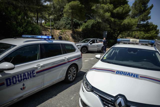French customs police search a vehicle at a rest stop on the A9 motorway between Narbonne and the Spanish border, on June 19, 2025. On the A9 motorway, which runs along the Mediterranean coast from Spain, Narbonne customs officers, flashing their lights and blaring their sirens, pull over suspicious vehicles in search of cocaine traffickers who are increasingly crossing the Franco-Spanish border, where more than 65 percent of the drugs supplying France already transit. (Photo by Ed JONES / AFP)