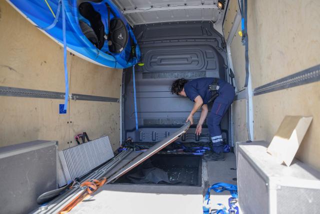 French customs police officer shows a concealed compartment in which drugs were found, in a confiscated van parked in an impound lot near Narbonne on June 19, 2025. On the A9 motorway, which runs along the Mediterranean coast from Spain, Narbonne customs officers, flashing their lights and blaring their sirens, pull over suspicious vehicles in search of cocaine traffickers who are increasingly crossing the Franco-Spanish border, where more than 65 percent of the drugs supplying France already transit. (Photo by Ed JONES / AFP)