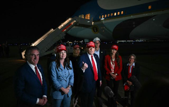 US Secretary of the Interior Doug Burgum (L), US Secretary of Agriculture Brooke Rollins (2L), US Secretary of Homeland Security Kristi Noem (2R) watch US President Donald Trump talk to journalists as they arrive at Joint Base Andrews, Maryland early on July 4, 2025. Trump returns from Iowa where he spoke at the Salute to America Celebration at the Iowa State Fairgrounds in Des Moines. (Photo by ANDREW CABALLERO-REYNOLDS / AFP)