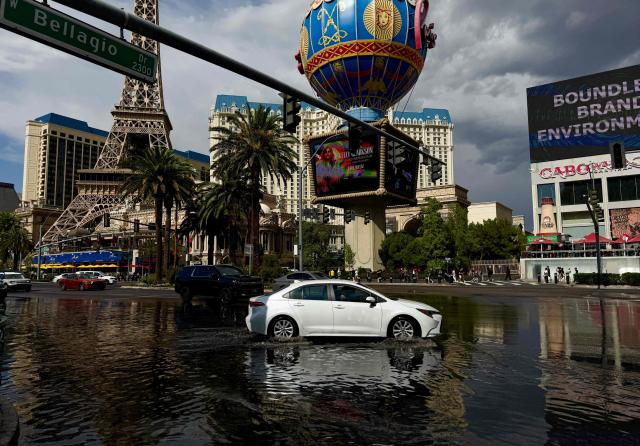A car drives through standing water as sporadic heavy rain flooded areas of the Las Vegas Strip, Nevada on July 3, 2025. (Photo by Daniel SLIM / AFP)