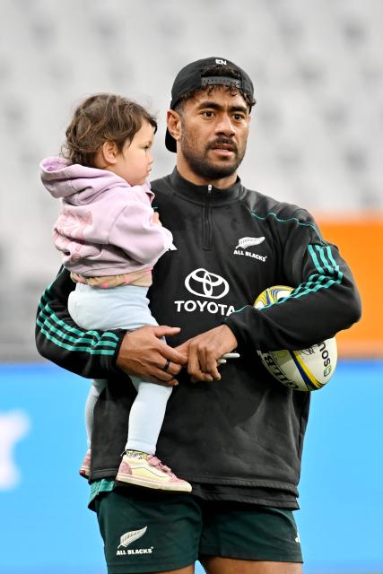 New Zealand's Emoni Narawa holds his daughter after the New Zealand captains' run at Forsyth Barr Stadium in Dunedin on July 4, 2025, ahead of their three-match international rugby series against France, with the first Test match to be played in Dunedin on July 5. (Photo by Sanka Vidanagama / AFP)