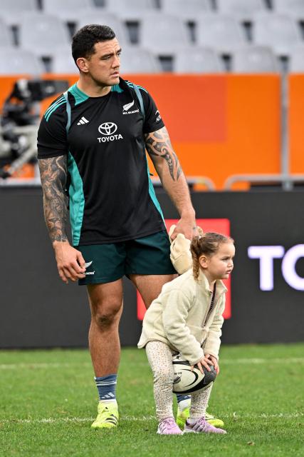 New Zealand's Codie Taylor looks on with his daughter after the New Zealand captains' run at Forsyth Barr Stadium in Dunedin on July 4, 2025, ahead of their three-match international rugby series against France, with the first Test match to be played in Dunedin on July 5. (Photo by Sanka Vidanagama / AFP)