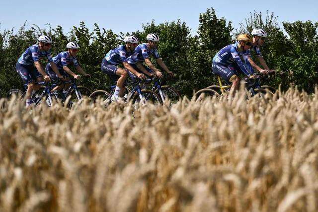 Soudal Quick-Step team's Belgian rider Remco Evenepoel (2nd R) and teammates cycle past wheat fields during a training session on the eve of the start of the 112th edition of the Tour de France cycling race, in Arras, northern France, on July 4, 2025. (Photo by Marco BERTORELLO / AFP)