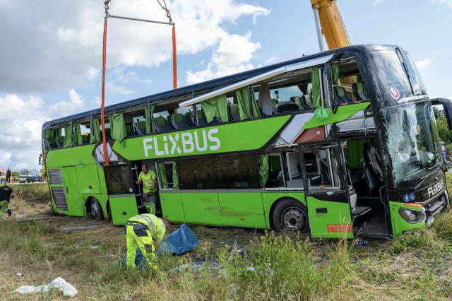 Cranes lift a flipped over bus from the company Flixbus, after an accident on the A19 highway near Roebel, northern Germany, on July 4, 2025, where some 20 people were injured. A Flixbus on the Copenhagen–Vienna route veered off the road to the right aon early July 4, 2025, shortly past the Roebel junction heading towards Berlin, and tipped onto its side, with 53 passengers and two bus drivers onboard. (Photo by Rene SCHROEDER / NEWS5 / AFP) / ALTERNATE CROP