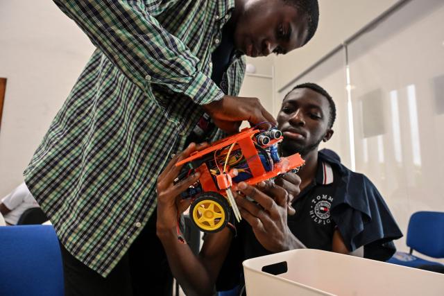Young robotic enthusiasts take part in the first edition of the National Robotic Competition on July 3, 2025 in Abidjan. (Photo by Issouf SANOGO / AFP)