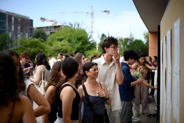 High school students check the results of the baccalaureat exam (French high school graduation exam) at the Lycee Vaclav-Havel high school in Begles, near Bordeaux, on June 4, 2025. (Photo by Christophe ARCHAMBAULT / AFP)