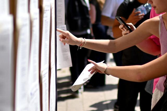High school students check the results of the baccalaureat exam (French high school graduation exam) at the Lycee Vaclav-Havel high school in Begles, near Bordeaux, on June 4, 2025. (Photo by Christophe ARCHAMBAULT / AFP)