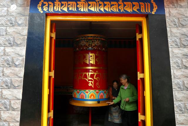 Women spin a prayer wheel at Nechung Monastery in McLeodganj on July 4, 2025. (Photo by Niharika Kulkarni / AFP)