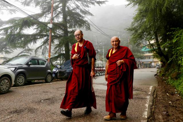 Buddhist monks walk along a road on a foggy day in McLeodganj on July 4, 2025. (Photo by Niharika Kulkarni / AFP)