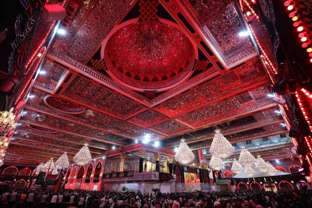 Shiite Muslim worshippers walk in a procession towards the Imam Hussein Shrine during a mourning ritual on the ninth day of the Muslim month of Muharram, in the lead-up to Ashura, a 10-day period commemorating the seventh century killing of Prophet Mohammed's grandson Imam Hussein, in the holy city of Karbala in southern Iraq on July 4, 2025. (Photo by AHMAD AL-RUBAYE / AFP)