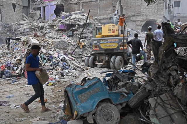 Rescue workers conduct a search operation amid the debris of a collapsed residential building in Karachi on July 5, 2025. Rescue teams pulled more bodies from the rubble of a five-storey building collapse in Pakistan overnight, taking the toll on July 5 to 14 as the recovery operation continued for a second day. (Photo by Rizwan TABASSUM / AFP)