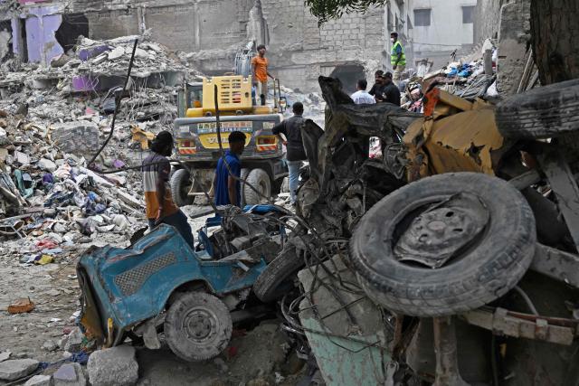 Rescue workers conduct a search operation amid the debris of a collapsed residential building in Karachi on July 5, 2025. Rescue teams pulled more bodies from the rubble of a five-storey building collapse in Pakistan overnight, taking the toll on July 5 to 14 as the recovery operation continued for a second day. (Photo by Rizwan TABASSUM / AFP)