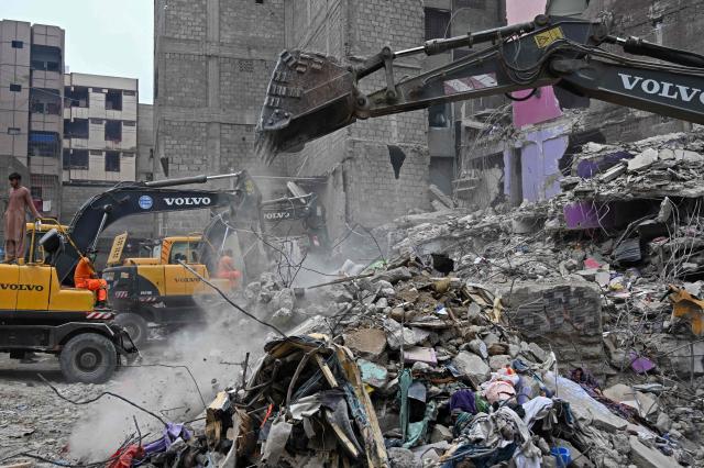 Rescue workers conduct a search operation amid the debris of a collapsed residential building in Karachi on July 5, 2025. Rescue teams pulled more bodies from the rubble of a five-storey building collapse in Pakistan overnight, taking the toll on July 5 to 14 as the recovery operation continued for a second day. (Photo by Rizwan TABASSUM / AFP)
