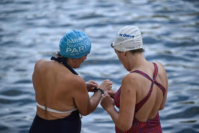 Swimmers get ready to enter the water at the Pont Marie safe bathing site on the Seine river on its opening day, in Paris on July 5, 2025. The River Seine reopened to Parisian swimmers this morning for the first time since 1923, offering locals and tourists a welcome respite after scorching temperatures. The seasonal opening of the Seine for swimming is seen as a key legacy of the Paris 2024 Olympics, when open water swimmers and triathletes competed in its waters which were specially cleaned for the event. (Photo by JULIEN DE ROSA / AFP)