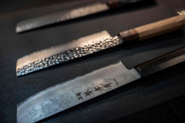 Japanese knives are seen on display at a store in Tokyo on July 5, 2025. (Photo by Yuichi YAMAZAKI / AFP)