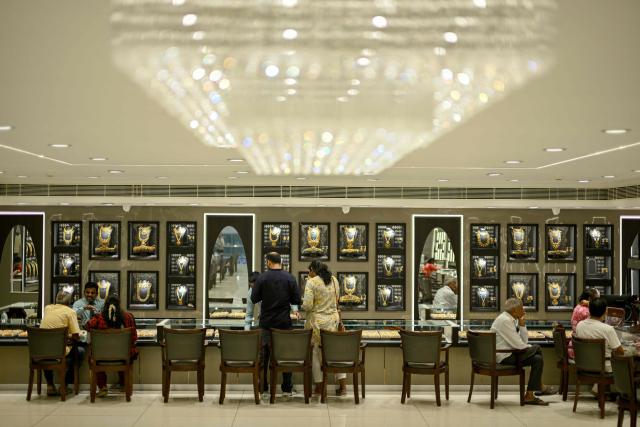 Customers buy gold ornaments at a jewellery store in Chennai on July 5, 2025. New Delhi and Washington have been locked in multiple rounds of talks, with hopes for an interim pact to avert the 26 percent "reciprocal" tolls meted out to India. (Photo by R. Satish BABU / AFP)