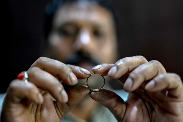 A goldsmith checks the shape of a ring at a workshop in Chennai on July 5, 2025. New Delhi and Washington have been locked in multiple rounds of talks, with hopes for an interim pact to avert the 26 percent "reciprocal" tolls meted out to India. (Photo by R. Satish BABU / AFP)