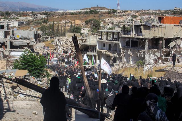 Shiite Muslim worshippers walk past the rubble of buildings destroyed by previous Israeli strikes during a mourning procession in Lebanon's southern village of Kfarkila near the border with Israel on July 5, 2025, which coincides with the ninth day of the Islamic month of Muharram in the lead-up to Ashura, a 10-day period commemorating the seventh century killing of Prophet Mohammed's grandson Imam Hussein. (Photo by Rabih DAHER / AFP)
