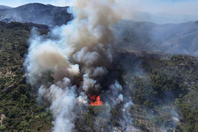 An aerial view shows smoke billowing from a forest fire in the coastal Syrian province of Latakia on July 5, 2025. Syrian emergency workers were battling forest fires raging in the coastal province of Latakia on Saturday for a third day in tough conditions as neighbouring Turkey sent assistance. Syria's ministry for emergencies and disaster management said teams from Turkey began helping on Saturday morning "as part of regional coordination to face the fires", with the assistance including two aircrafts and eight fire trucks. (Photo by OMAR HAJ KADOUR / AFP)