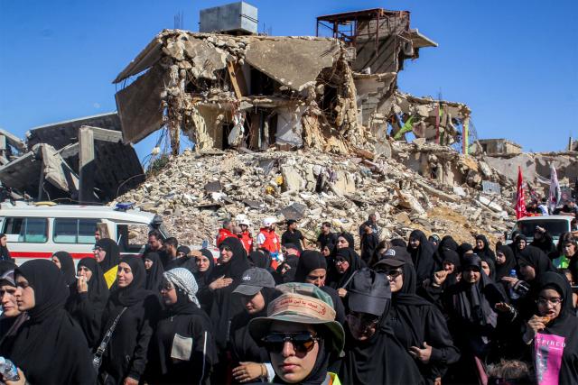 Shiite Muslim worshippers walk past the rubble of buildings destroyed by previous Israeli strikes during a mourning procession in Lebanon's southern village of Kfarkila near the border with Israel on July 5, 2025, which coincides with the ninth day of the Islamic month of Muharram in the lead-up to Ashura, a 10-day period commemorating the seventh century killing of Prophet Mohammed's grandson Imam Hussein. (Photo by Rabih DAHER / AFP)