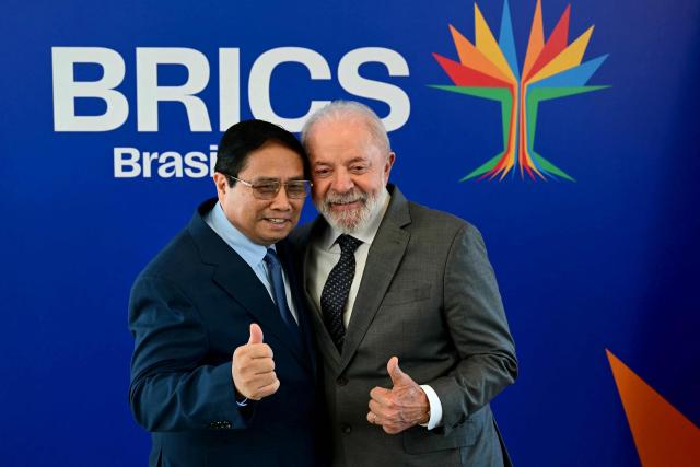 Vietnam's Prime Minister Pham Minh Chinh (L) and Brazil's President Luiz Inacio Lula da Silva gives the thumbs up before a bilateral meeting ahead of the BRICS summit in Rio de Janeiro, Brazil, on July 5, 2025. BRICS leaders meeting in Rio de Janeiro from Sunday are expected to decry Donald Trump's hardline trade policies, but are struggling to bridge divides over crises roiling the Middle East. (Photo by Pablo PORCIUNCULA / AFP)