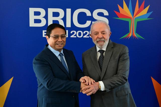 Vietnam's Prime Minister Pham Minh Chinh (L) and Brazil's President Luiz Inacio Lula da Silva shake hands before a bilateral meeting ahead of the BRICS summit in Rio de Janeiro, Brazil, on July 5, 2025. BRICS leaders meeting in Rio de Janeiro from Sunday are expected to decry Donald Trump's hardline trade policies, but are struggling to bridge divides over crises roiling the Middle East. (Photo by Pablo PORCIUNCULA / AFP)