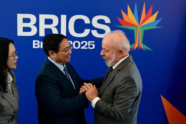 Vietnam's Prime Minister Pham Minh Chinh (L) is greeted by Brazil's President Luiz Inacio Lula da Silva before a bilateral meeting ahead of the BRICS summit in Rio de Janeiro, Brazil, on July 5, 2025. BRICS leaders meeting in Rio de Janeiro from Sunday are expected to decry Donald Trump's hardline trade policies, but are struggling to bridge divides over crises roiling the Middle East. (Photo by Pablo PORCIUNCULA / AFP)