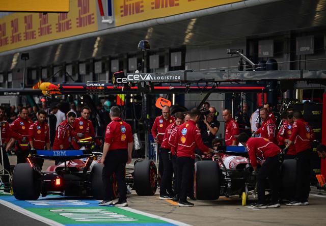 Ferrari's British driver Lewis Hamilton (L) and Ferrari's Monegasque driver Charles Leclerc (R) by their garage during the qualifying session ahead of the Formula One British Grand Prix at the Silverstone motor racing circuit in Silverstone, central England, on July 5, 2025. (Photo by Ben STANSALL / POOL / AFP)