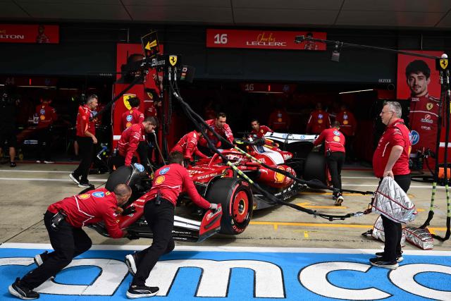 The Ferrari of Monegasque driver Charles Leclerc is pushed back into his garage during the qualifying session ahead of the Formula One British Grand Prix at the Silverstone motor racing circuit in Silverstone, central England, on July 5, 2025. (Photo by Ben STANSALL / POOL / AFP)