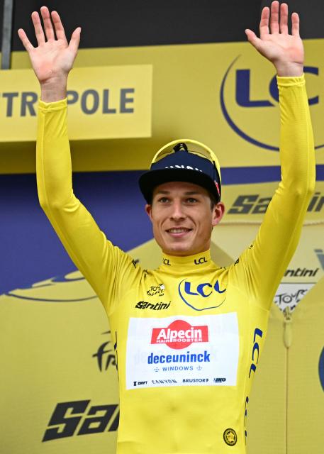 Alpecin - Deceuninck team's Belgian rider Jasper Philipsen celebrates on the podium with the overall leader's yellow jersey after the 1st stage of the 112th edition of the Tour de France cycling race, 184.9 km starting and finishing in Lille Metropole, northern France, on July 5, 2025. (Photo by Loic VENANCE / AFP)