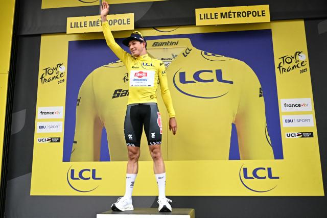 Alpecin - Deceuninck team's Belgian rider Jasper Philipsen celebrates on the podium with the overall leader's yellow jersey after the 1st stage of the 112th edition of the Tour de France cycling race, 184.9 km starting and finishing in Lille Metropole, northern France, on July 5, 2025. (Photo by Loic VENANCE / AFP)