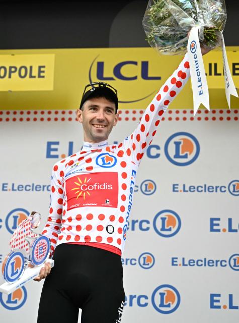Cofidis team's French rider Benjamin Thomas celebrates on the podium with the best climber's polka dot (dotted) jersey after the 1st stage of the 112th edition of the Tour de France cycling race, 184.9 km starting and finishing in Lille Metropole, northern France, on July 5, 2025. (Photo by Loic VENANCE / AFP)