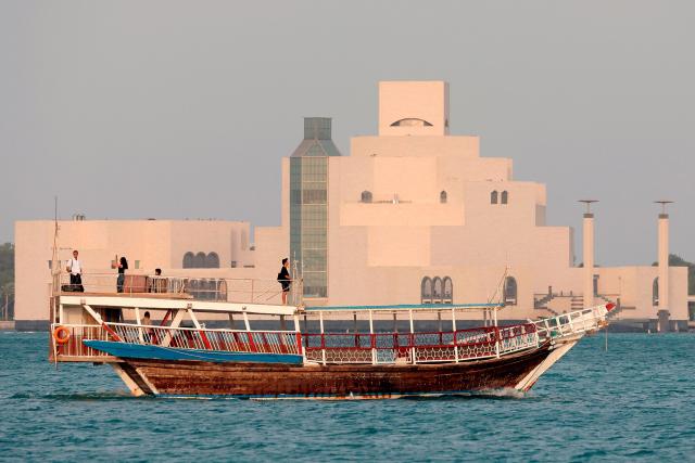A traditional dhow boat transports tourists in front of the Doha skyline on July 5, 2025. (Photo by Karim JAAFAR / AFP)