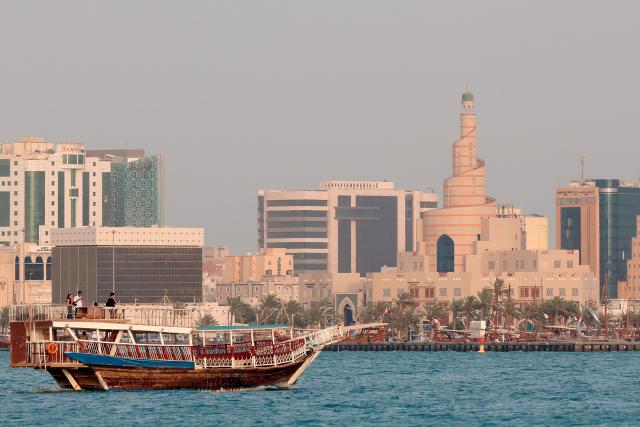 A traditional dhow boat transports tourists in front of the Doha skyline on July 5, 2025. (Photo by Karim JAAFAR / AFP)