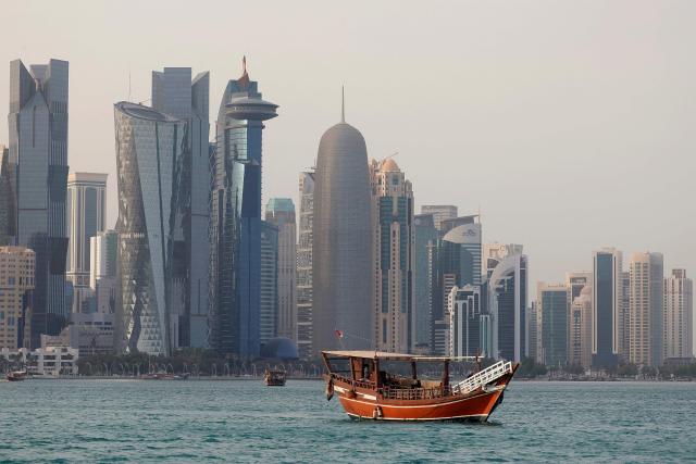A traditional dhow boat transports tourists in front of the Doha skyline on July 5, 2025. (Photo by Karim JAAFAR / AFP)